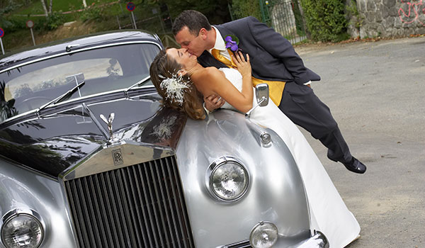 The bridal couple kissing on a vintage car in Donosti, Guipuzcoa, Basque Country